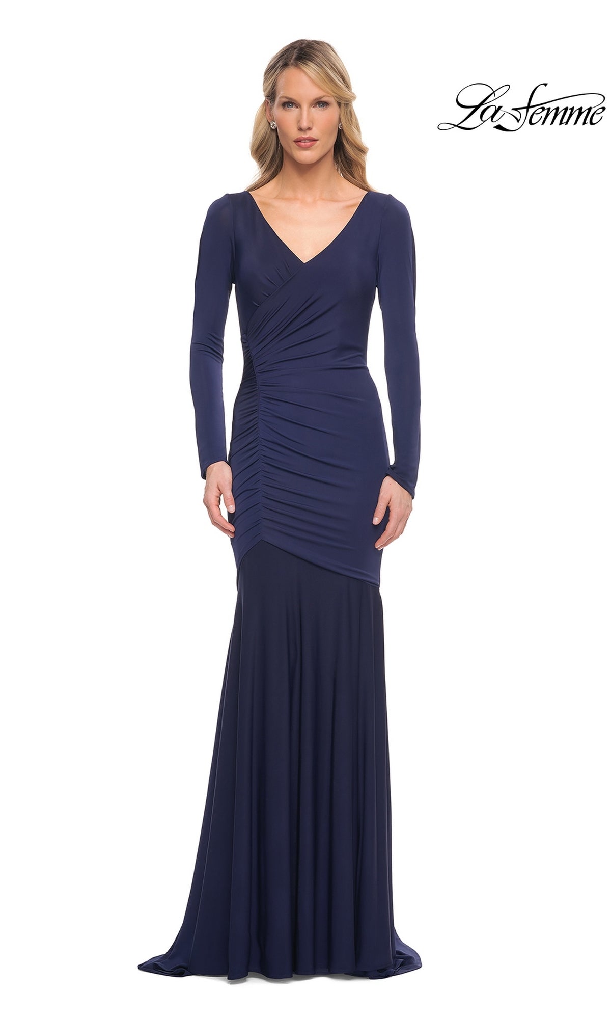 A woman wears a navy Long Formal Dress: La Femme 30010, a long-sleeve mermaid gown featuring a V-neckline and gathered detailing at the side of the waist.